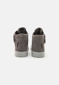 Zapatillas altas de ante gris con acentos en rosa y logo en el talón. Presenta una suela de goma gris y cremallera lateral para facilitar su uso.
