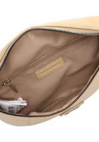 Interno di una borsa beige testurizzata con una tasca con zip e foderato liscio. Presenta una chiusura con cerniera e un'etichetta impressa.