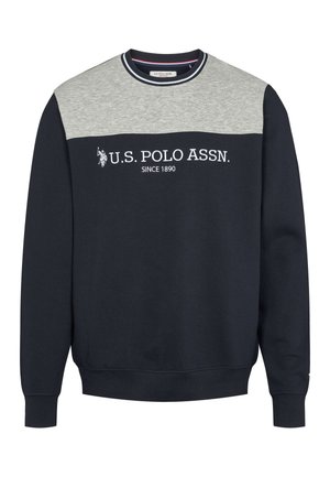 Námořnicky modrá mikina s šedým panelem na rameni, bílým nápisem „U.S. POLO ASSN.“ a „SINCE 1890.“. Má žebrovaný límec a manžety, jemnou texturu látky.
