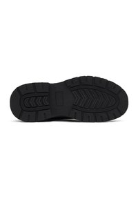 Suela de zapato de goma negra con surcos profundos y patrón de espiga para tracción. Perfil plano con una sección central suave y sólida.