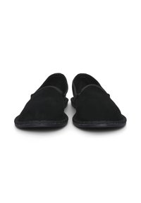 Chaussures slip-on en daim noir avec une texture douce, bout rond et un détail de couture sur le bord. Conception à dos fermé avec un haut élastique pour le confort.