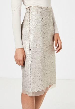 Kokerrok tot op de knie in metallic zilverkleurige stof met een gestructureerde afwerking, voorzien van een transparante volant aan de zoom en een zijnaaddetail.