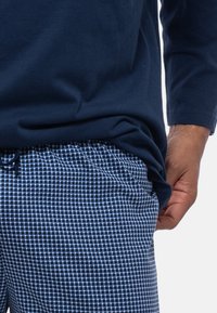 Paita pitkähiha, merivoimien sininen, valmistettu puuvillasta, yhdistetty siniraidallisiin oleskeluhousuihin, joissa on joustava vyötärö ja kiristysnauha.