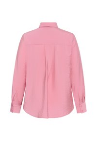 Blouse rose clair à manches longues avec un pli dans le dos, des poignets boutonnés et un col classique, vue de dos sur fond blanc.