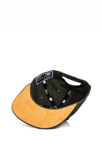 Cappello di tessuto verde con visiera in suede beige. All'interno presenta una fodera a fantasia con etichette di branding e fori di ventilazione. Il cappello ha una forma curva.