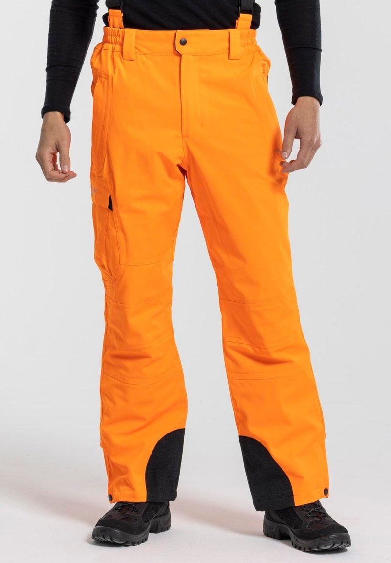Oranje waterdichte broek met verstelbare bretels, cargozakken en zwarte accenten bij de broekspijpen. Geschikt voor buitenactiviteiten in koud weer.