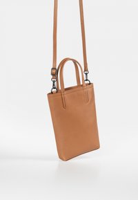 Braune Lederhandtasche mit strukturierter Oberfläche, vertikal rechteckiger Form, kurzen oberen Griffen und einem verstellbaren langen Tragegurt.