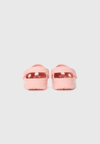 Light pink Crocs clogs with an open design, large cutouts, and adjustable heel straps. Textured soles for grip and comfort.
