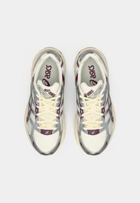 Αθλητικά παπούτσια με ασημί διχτυωτό επάνω μέρος, κρεμ λεπτομέρειες, μπορντό στοιχεία και μπεζ σόλα; διαθέτουν επίπεδες κορδόνες και επενδεδυμένη σόλα.