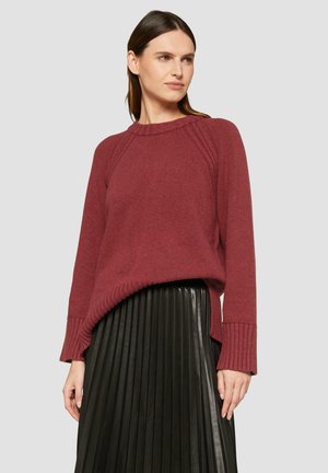 Bordeaux breien trui met een geribbelde zoom en manchetten, gecombineerd met een geplooide zwarte faux leren rok, met een relaxte pasvorm en raglanmouwen.