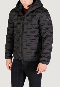 Giubbotto imbottito nero con design trapuntato, dotato di zip frontale, cappuccio e tasche laterali. Realizzato in materiale leggero e isolante.