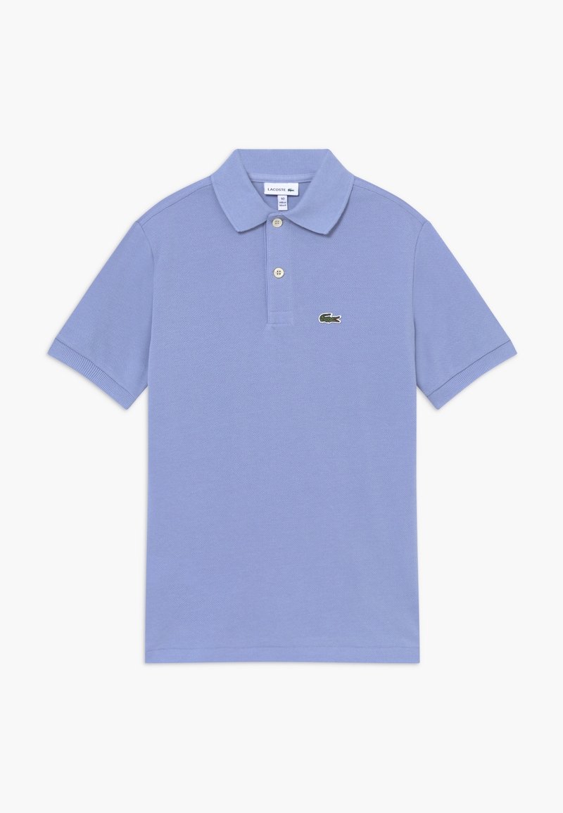 Ljusblå polo shirt gjord av texturerat tyg, med en tvåknäppning och en grön broderad logga på vänster bröst.