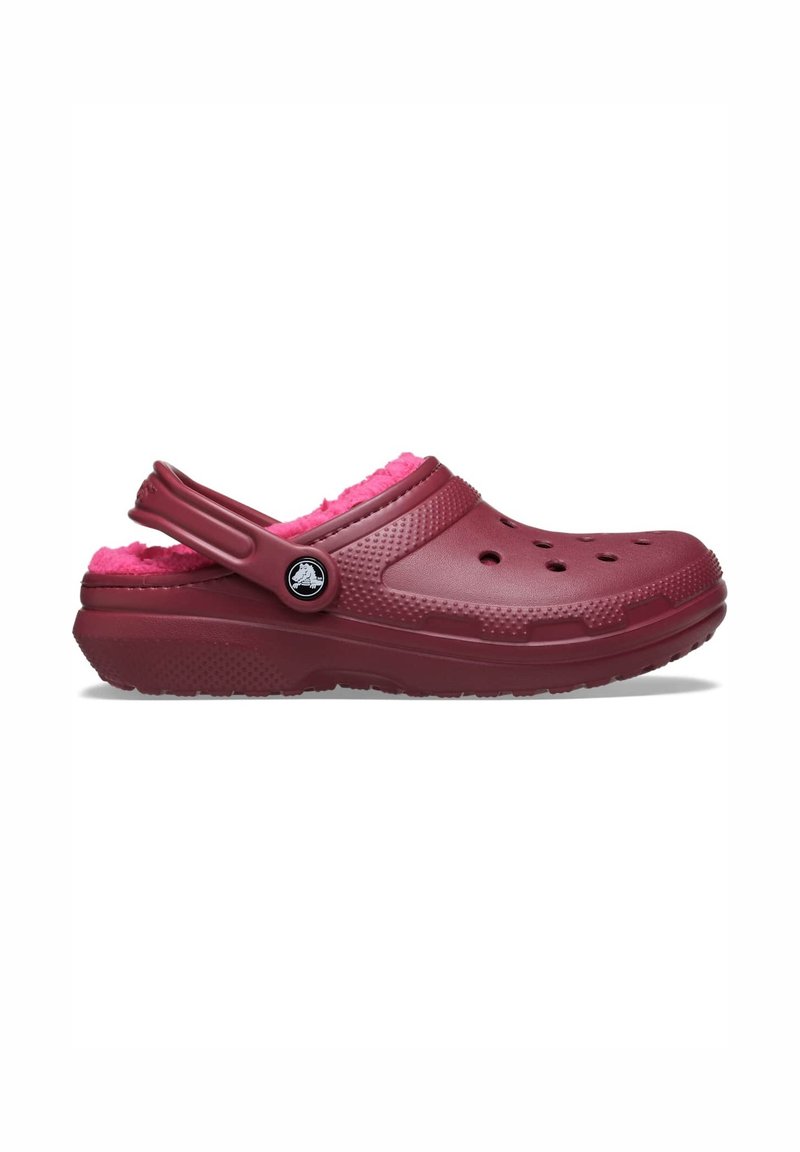 Burgunderfarbener Clog mit pinkem, flauschigem Innenfutter, im Slip-On-Design, runden Belüftungslöchern und verstellbarem Riemen hinten. Texturierte Außensohle für besseren Grip.