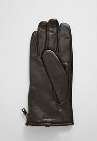 Guanto in pelle nera con una superficie liscia, dotato di quattro dita e una zona del palmo imbottita. Include un polsino con zip per una vestibilità regolabile.