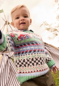 Knit sweater featuring multi-colored patterns, including reds, greens, and blues, with a ribbed mint green collar and cuffs.