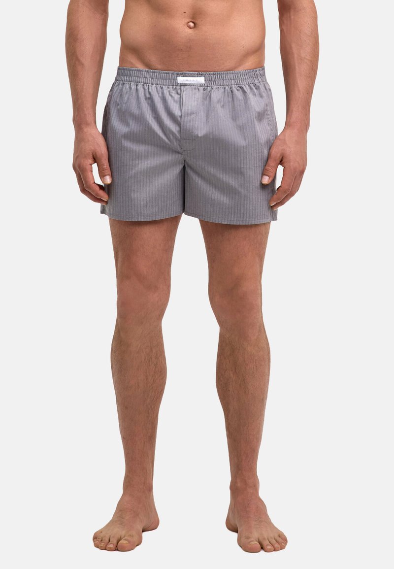 Shorts de bain gris rayés avec une taille élastique, un matériau léger et une coupe décontractée, arrivant à mi-cuisse, conçus pour le confort.
