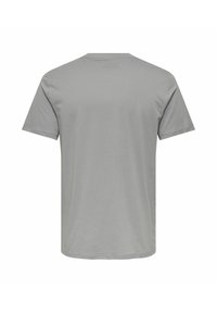 Camiseta gris de manga corta hecha de material de algodón, con cuello redondo y una textura suave sin patrones ni acentos visibles.