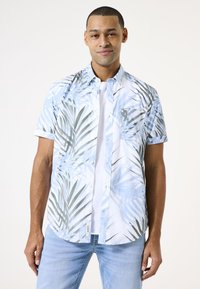 Camisa de botones de manga corta en blanco con patrones de hojas de palma en azul y verde, que incluye un bolsillo en el pecho y un dobladillo curvado.