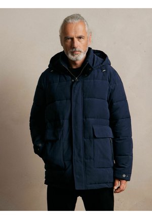 Granatowa pikowana kurtka z kapturem, z dwoma przednimi kieszeniami, zapięciem na zamek błyskawiczny i widocznymi wzorami przeszyć, na neutralnym tle.