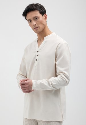 Camicia beige a maniche lunghe con scollo henley e tre bottoni marroni. Realizzata in un tessuto morbido con una texture liscia e una vestibilità comoda.