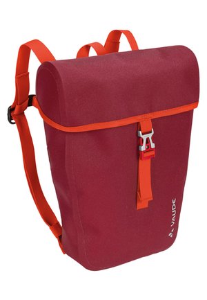 Sac à dos en tissu rouge avec une sangle orange, doté d'une fermeture enroulable, de quincaillerie en métal argenté et d'un logo sur le côté. Texture lisse avec une forme structurée.