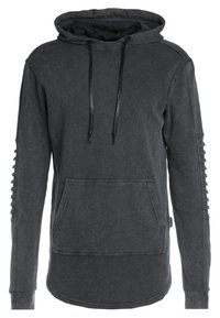 Mikina s kapucí v tmavě šedé tkanině, s přední kapsou a texturovanými detaily podél rukávů. Stahovací šňůrka u kapuce.