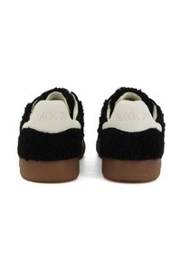 Sneakers neri in pile a taglio basso con tallone bianco stampato "BACK 70" e suola in gomma marrone, viste di spalle.