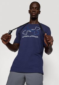 Ναυτικό μπλε T-shirt Under Armour με κοντά μανίκια και μεγάλο λογότυπο. Διαθέτει απαλό βαμβακερό υλικό και κλασική λαιμόκοψη.