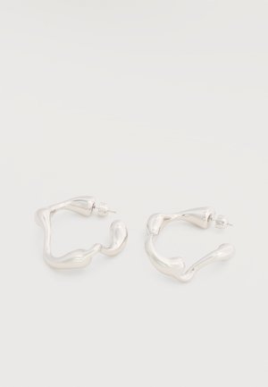 Par uhanov iz neravnih srebrnih obročev z zadnjimi zatiči na belem ozadju.