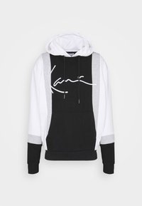Felpa con cappuccio caratterizzata da blocchi di colore nero, bianco e grigio. Include una tasca frontale e un logo in scrittura bianca sul petto.