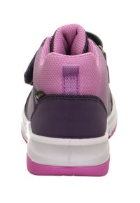 Lila Sportschuh mit Mesh-Obermaterial, pinken Akzenten und verstärktem Absatz. Verfügt über einen Klettverschlussriemen und eine strukturierte Sohle für besseren Halt.