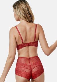 Ensemble soutien-gorge en dentelle rouge et culotte taille haute présentant des motifs floraux complexes, des bretelles réglables et une fermeture à agrafes dans le dos.