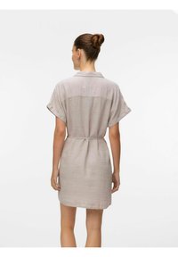Kurzärmeliges Leinenkleid in hellbeige mit tailliertem Schnitt und Kragen; verfügt über eine Rückenpasse und eine weiche Textur.