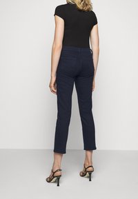 Mörk tvättade jeans med slim fit, med en medelhög midja, fyra fickor och en något beskuren längd ovanför vristen.