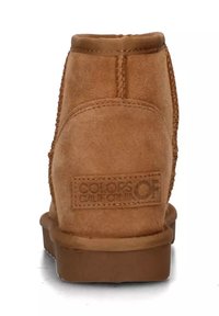 Stivaletti alla caviglia in suede beige con punta arrotondata e interno morbido. Presentano cuciture a vista e una patch con il marchio sul retro. Suola piatta in gomma.