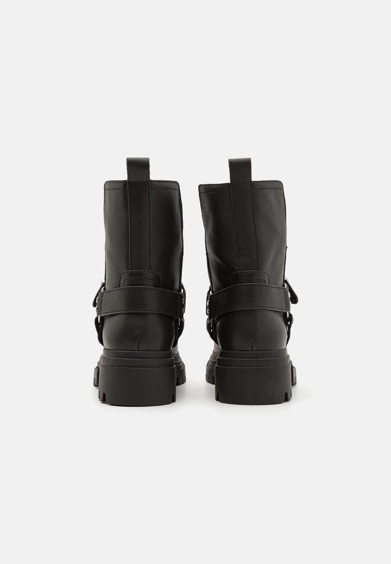 Czarne skórzane botki za kostkę o gładkim wykończeniu, z paskiem z klamrą, niską grubą podeszwą oraz uchwytami z tyłu dla łatwego zakładania.