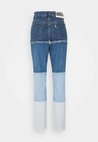 Pantalones de mezclilla con diseño de patchwork, tonos de azul variados y dobladillos deshilachados, con una cintura alta y estilo clásico de cinco bolsillos.