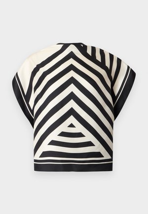 Žena stoji s rukom u džepu, nosi top crno-bijelog geometrijskog uzorka, bijele hlače, crni remen i crne cipele na nisku petu sa špicastim vrhom.