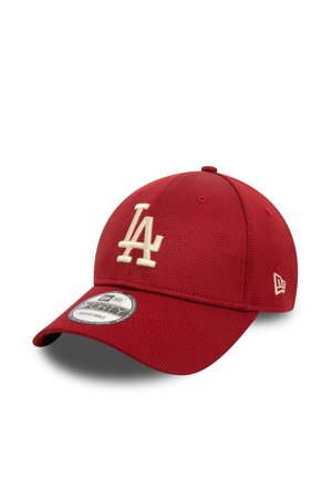 Casquette de baseball rouge en tissu texturé, avec un logo crème "LA", une visière incurvée et un dos ajustable. Style New Era 39THIRTY.