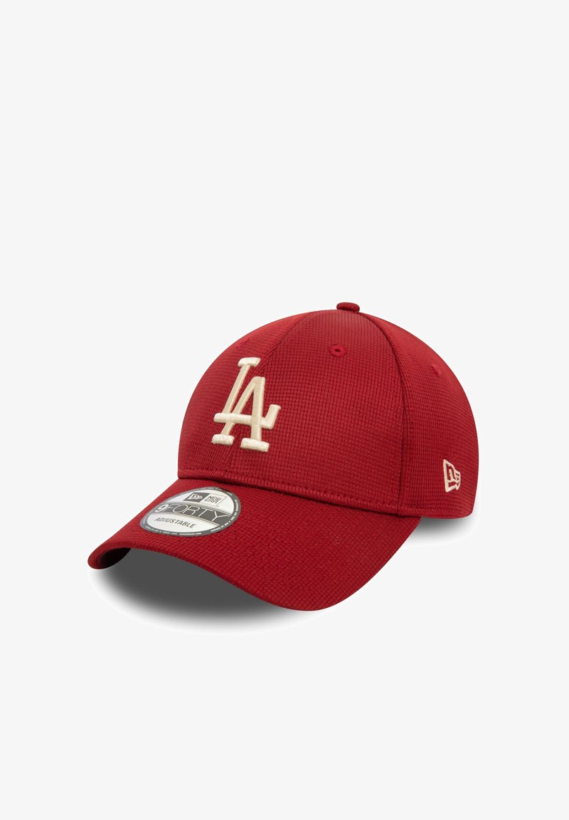 Casquette de baseball rouge en tissu texturé, avec un logo crème "LA", une visière incurvée et un dos ajustable. Style New Era 39THIRTY.