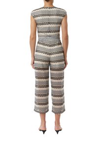 Woven jumpsuit w zygzakowy wzór w kolorze czarnym, białym i odcieniach beżu; krótki rękaw i skrócone szerokie nogawki; materiał o fakturze.