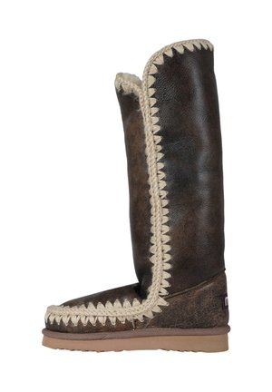 Stivale alto in pelle marrone con finitura testurizzata, caratterizzato da una rifinitura intrecciata color crema lungo il bordo e una robusta suola in gomma per una migliore aderenza.