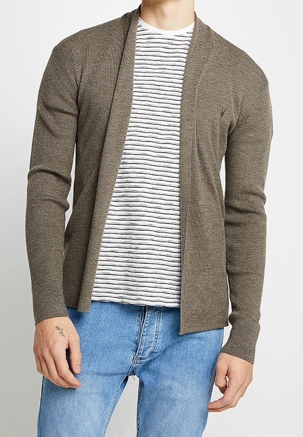 Cardigan marrone a coste con design a apertura frontale, indossato sopra una t-shirt bianca a righe blu navy, abbinato a jeans azzurri.