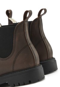 Braune Leder-Chelsea-Stiefel mit elastischen Seitenteilen, Zuglaschen und robusten schwarzen Gummisohlen. Enthält genähte Details für Langlebigkeit.