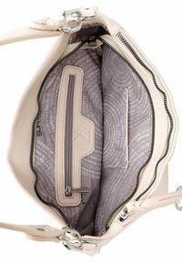Sac à main en cuir couleur crème avec des accessoires en métal argenté, comprenant un intérieur zippé, une poche et une doublure à motifs.