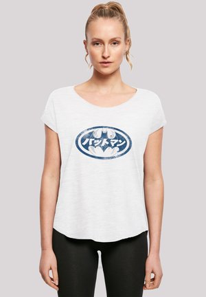 Hvit bomulls t-skjorte med et blått grafisk logo med tekst. Korte ermer og rund hals. Litt lenger bakhem.