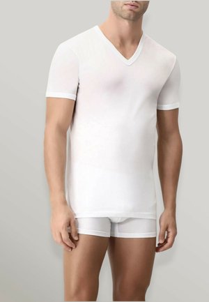 Camicetta bianca a V con maniche corte realizzata in tessuto leggero, abbinata a boxer bianchi coordinati, con delicati dettagli a contrasto.