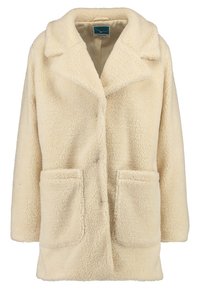 Cappotto teddy color crema con ampi rever, due tasche applicate frontali e una texture morbida e pelosa.
