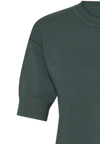 Top verde a coste in maglia con scollo rotondo e maniche corte. Presenta un tessuto liscio e strutturato e una vestibilità leggermente rilassata.