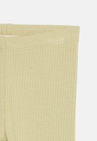 Κοντινό πλάνο μπεζ ριμπ ύφασμα με διπλωμένο τελείωμα και ορατή ραφή κατά μήκος της κορυφαίας ακμής.